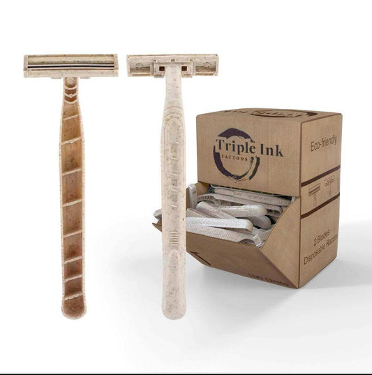 Disposable Razors with cream and beige handles, dual-blade heads and textured grips beside an open cardboard dispenser